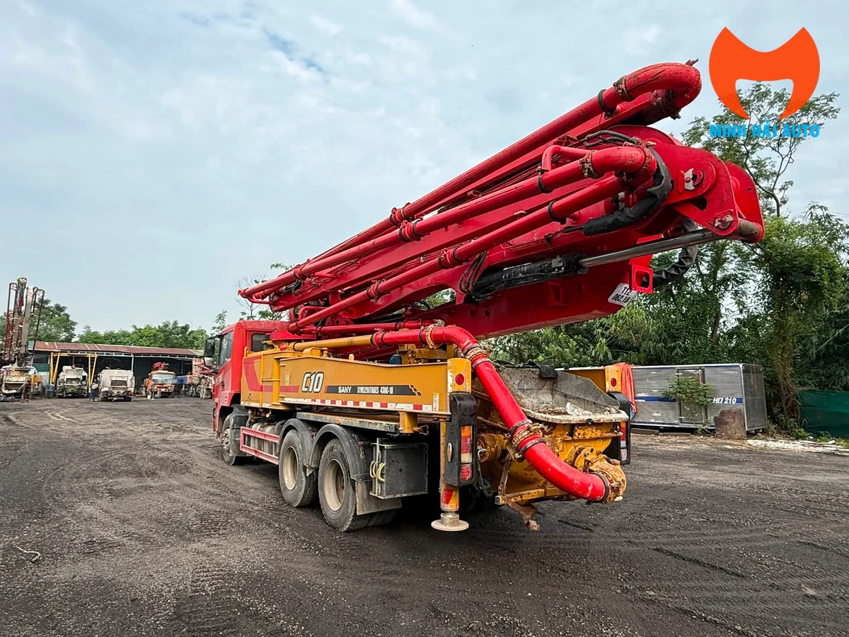 Xe bơm bê tông cần gập nhìn từ phía sau với cụm ống nạp