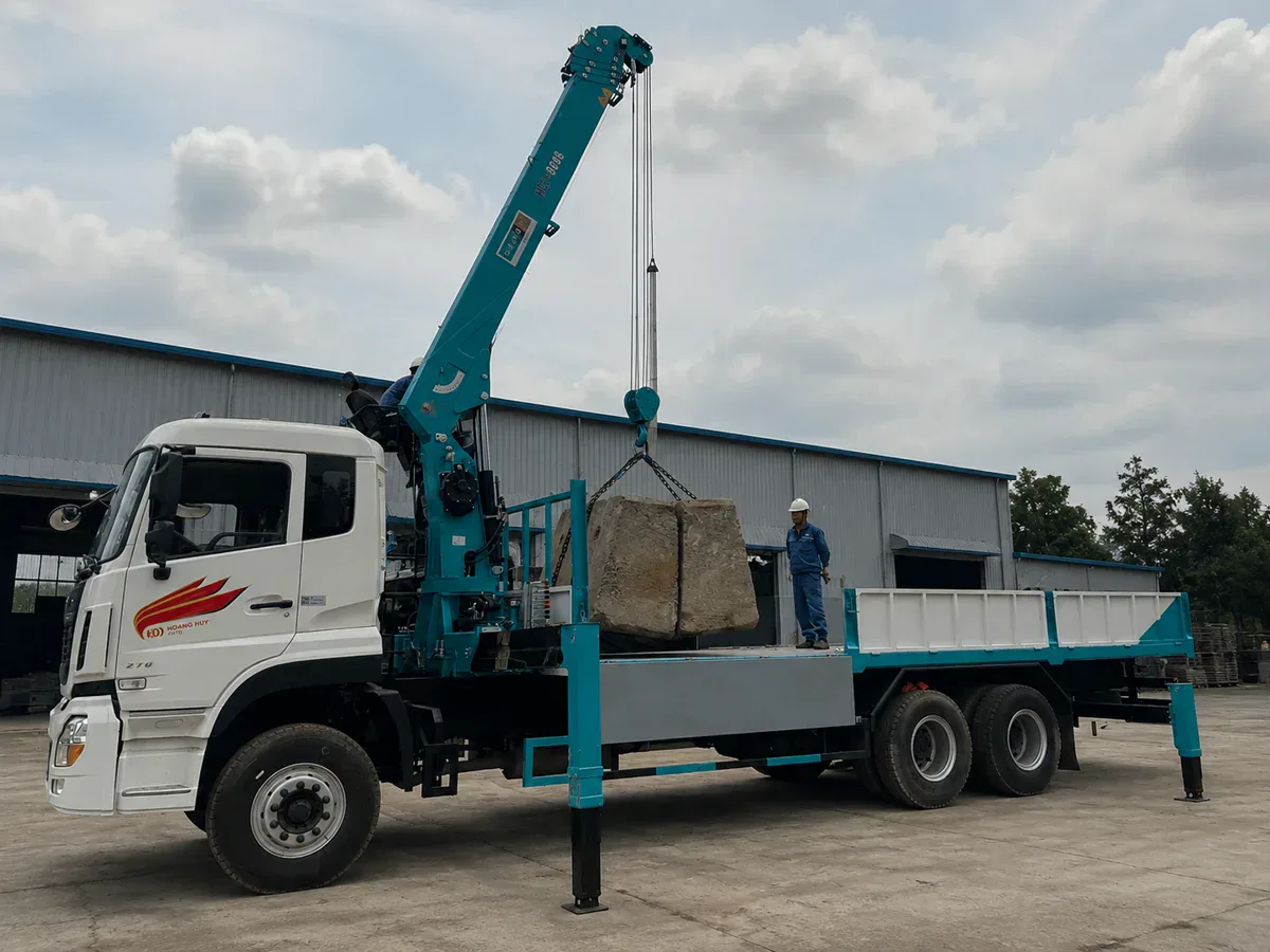 Xe tải gắn cẩu mở chân chống và nâng tải tại bãi
