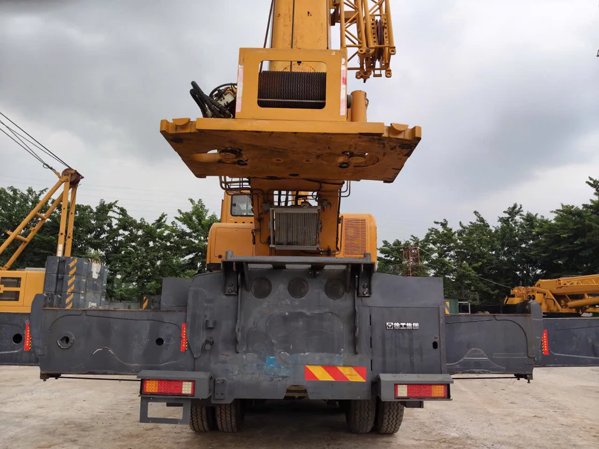 Phía sau xe cẩu bánh lốp cũ với cụm tời và chân chống