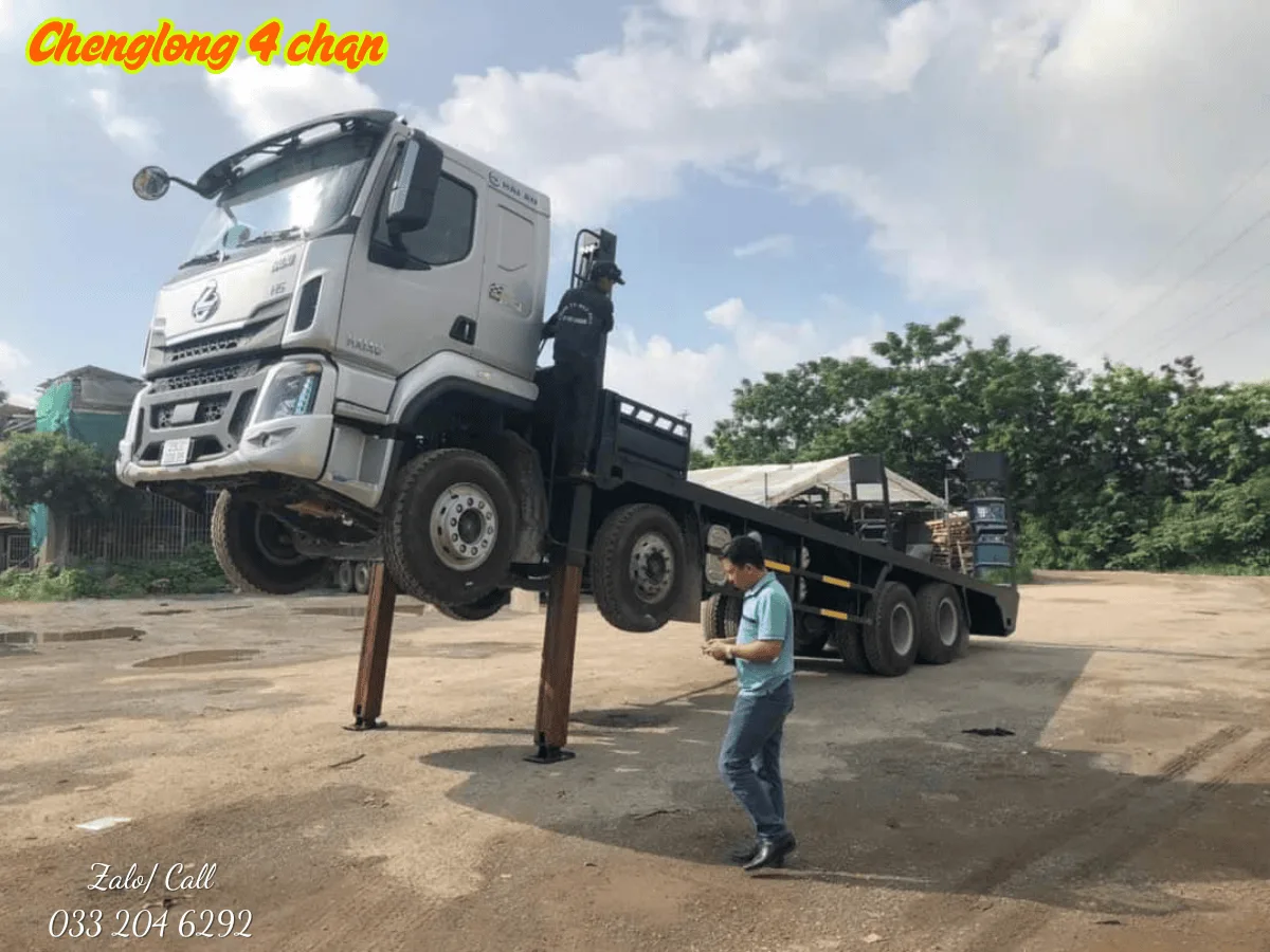 Xe nâng đầu Chenglong 4 chân đang vận chuyển máy xúc công trình