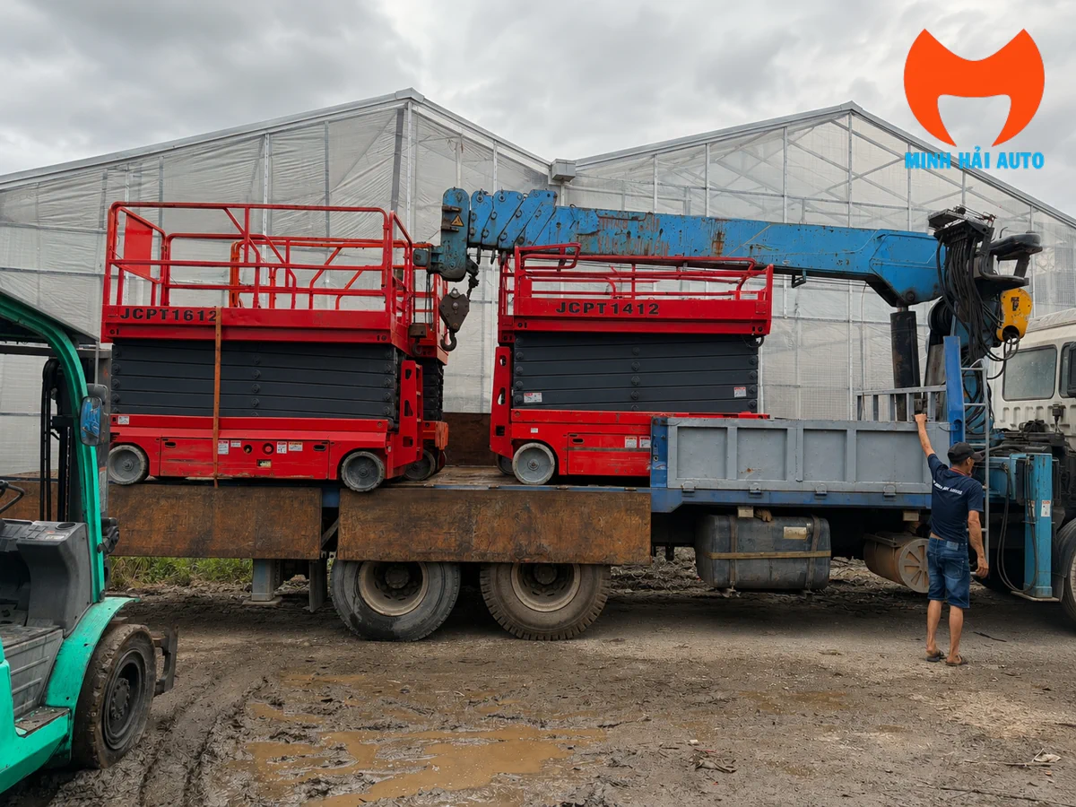 Xe nâng người cắt kéo được xếp dỡ lên xe tải tại công trình