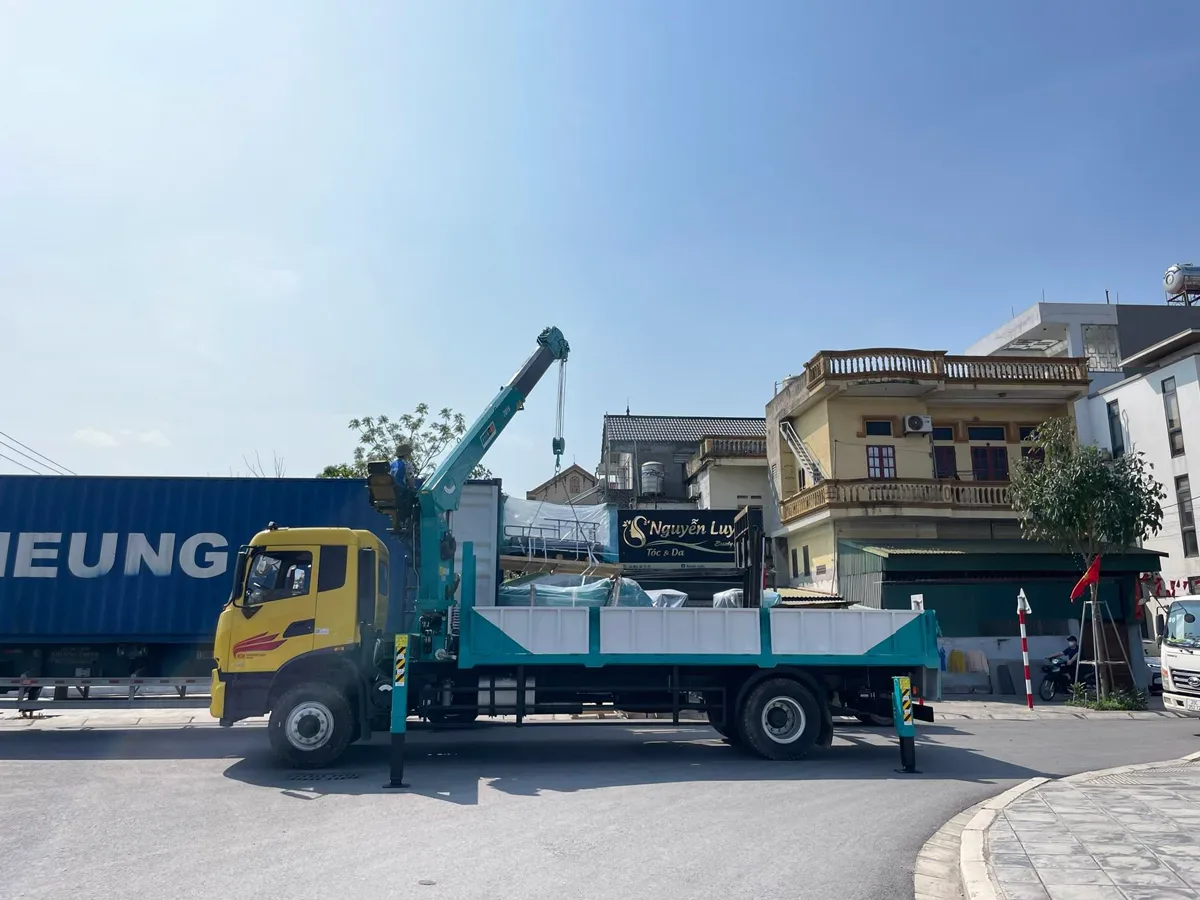 Xe tải gắn cẩu triển khai chân chống trước khi nâng hạ